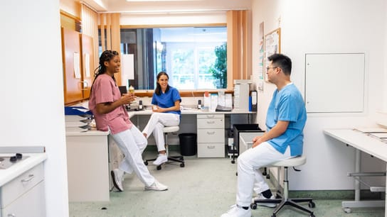 Personal del hospital tomando café y conversando durante el descanso. Trabajadores del área de cuidado de la salud hombres y mujeres conversando informalmente durante un descanso en el hospital.