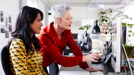 Mature business woman mentoring younger employee.