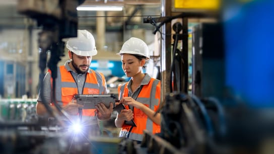 Ingegneri che osservano le unità di saldatura del braccio robotico in funzione in fabbrica.