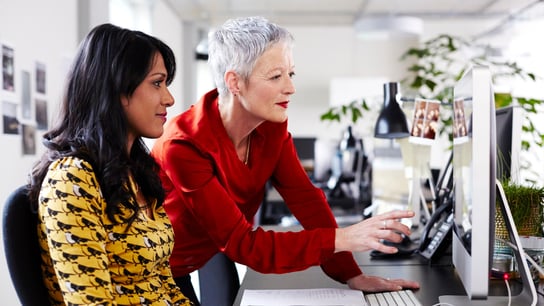 Mature business woman mentoring younger employee.
