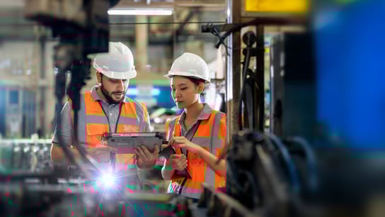 Engineers observing the Robotics arm welding units operating at factory.