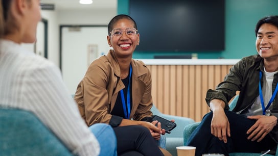 A group of healthcare professionals sitting in chairs around a wooden table in a staff common room in a hospital in Newcastle upon Tyne, North East England.