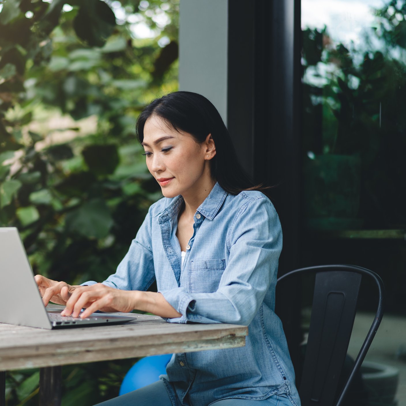 Happy Asian female using laptop working outdoors, web conference, remote work concept.