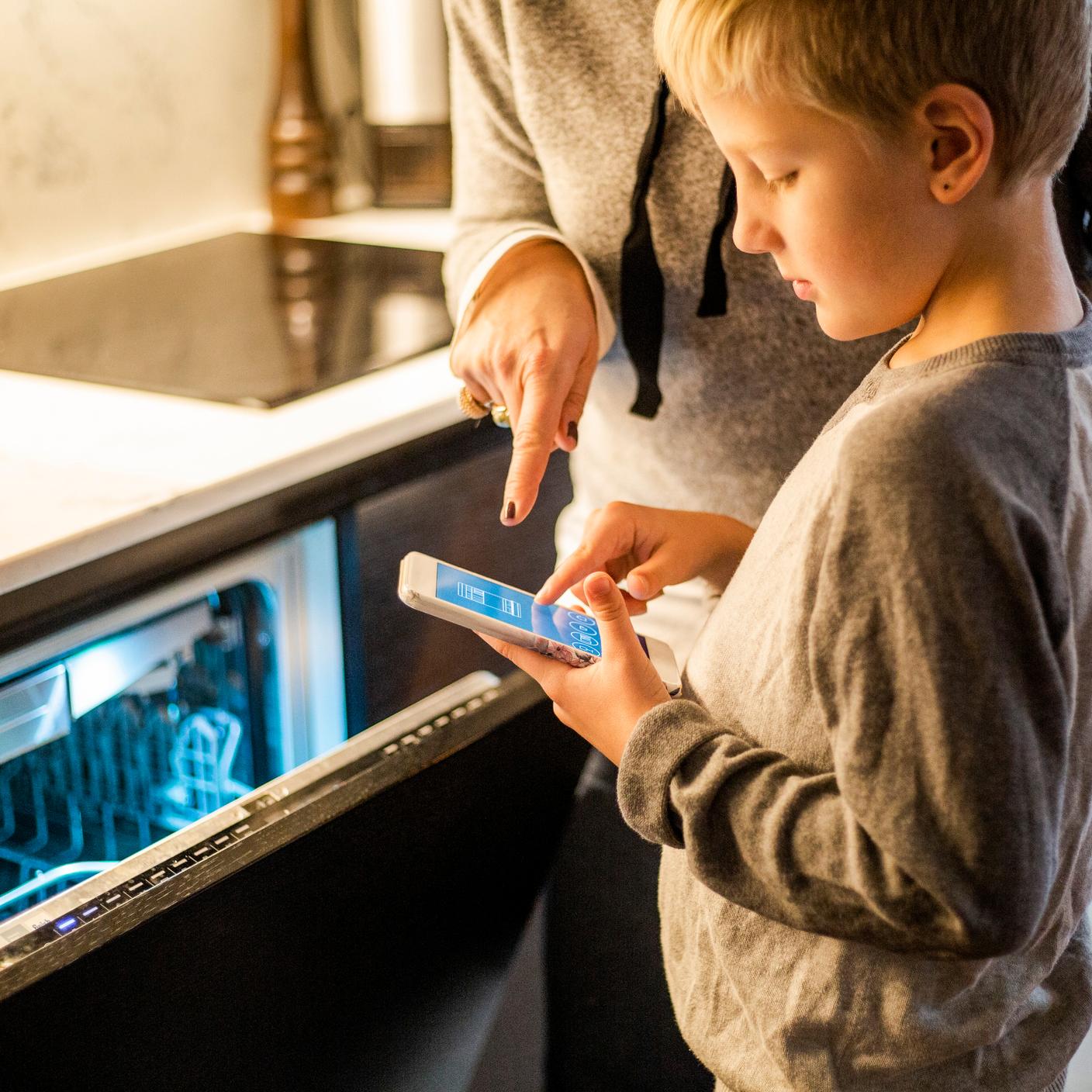 Soutenir le passage à un système à faible consommation d’énergie - un garçon utilisant une application mobile avec sa mère