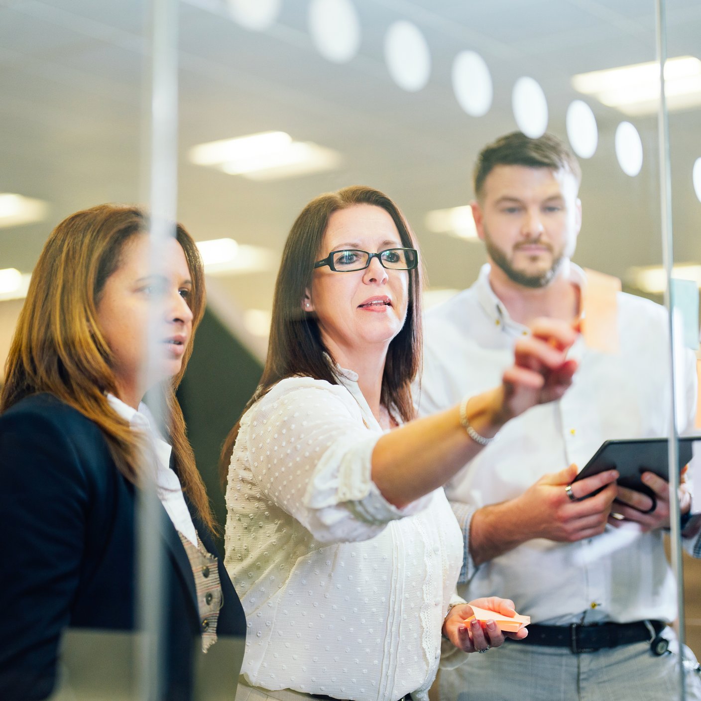 ボードの前で議論する3人