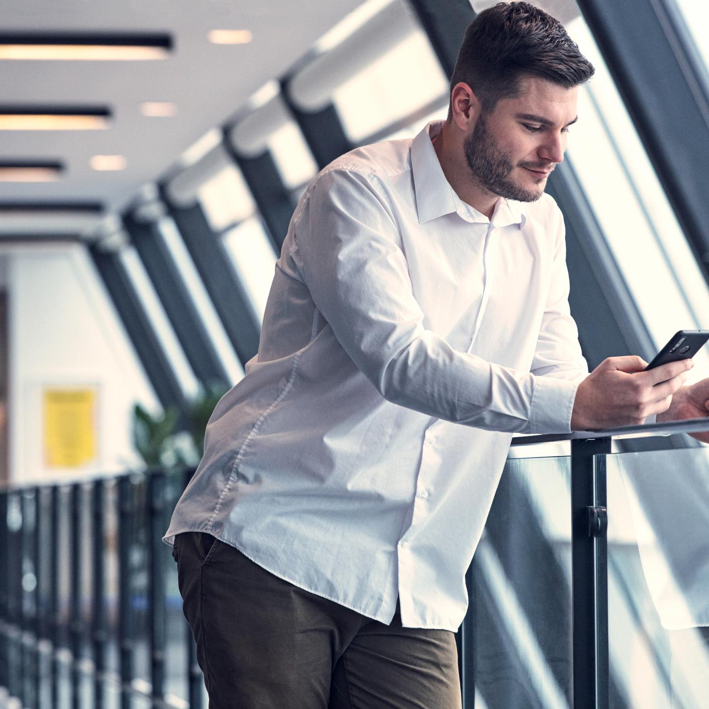 携帯電話でカード決済をする男性