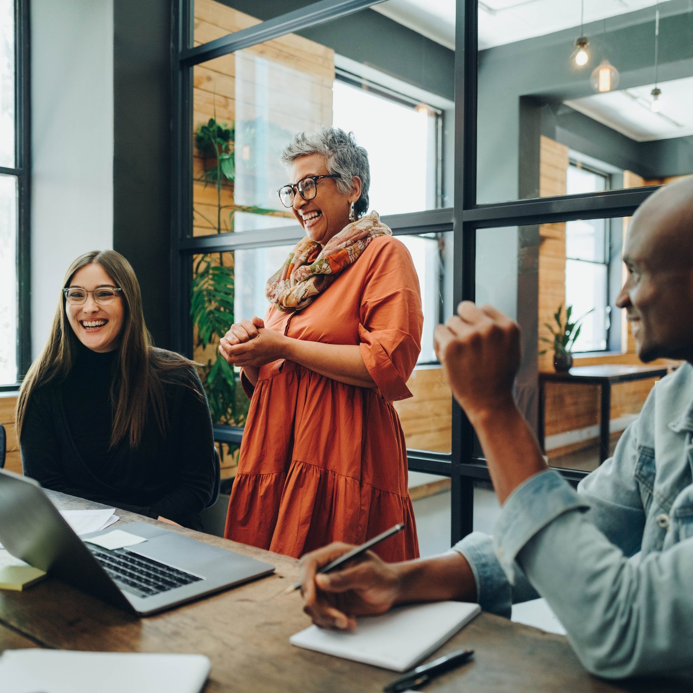 Diverse businesspeople smiling cheerfully during a meeting in a modern office. Group of successful businesspeople working as a team in a multicultural workplace.