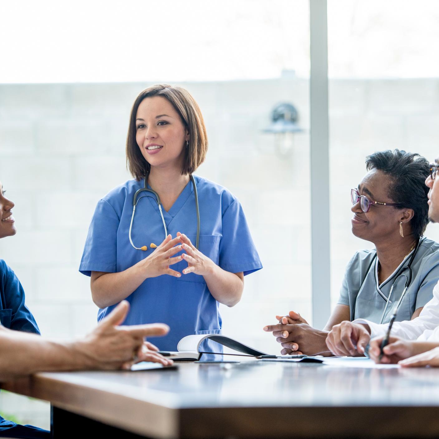 A multi-ethnic group of medical staff are indoors in a hospital.