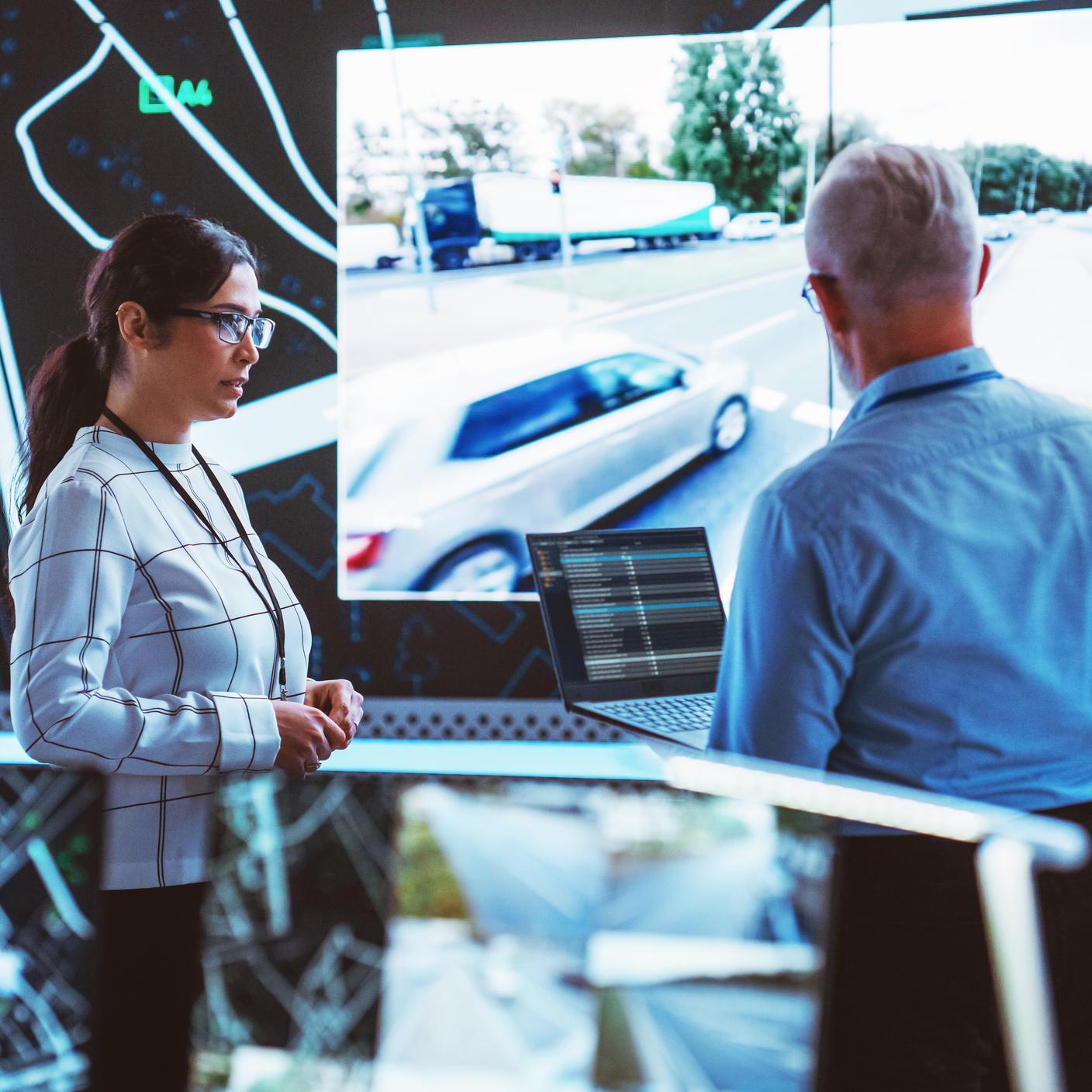 man and women looking at large screen 