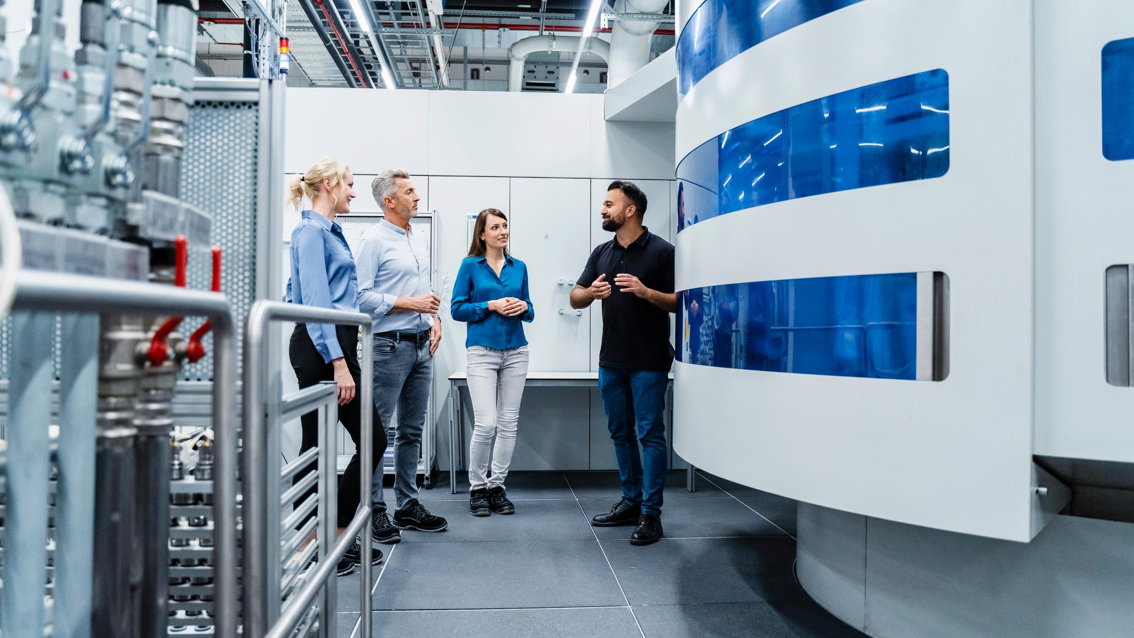 Engineer discussing with businessman and businesswomen at automated industry
