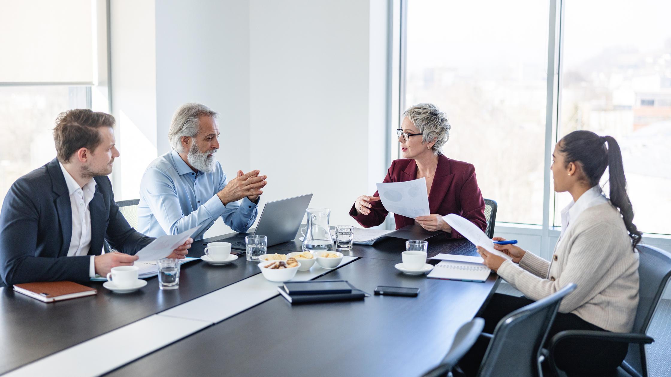 Four people sitting around a table having a business meeting
